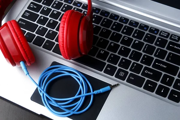 Foto de fones de ouvido estéreo e um computador portátil — Fotografia de Stock