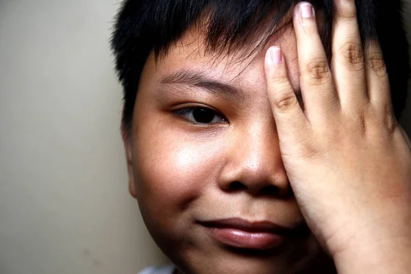 Fiatal ázsiai fiú, amely az egyik szeme — Stock Fotó