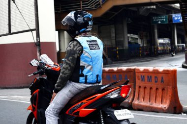 Popüler motosikletli taksi şoförü trafik ışığının yeşile dönmesini bekliyor..