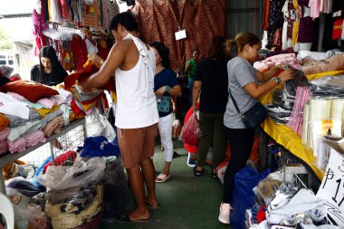 Pazarda satılan çeşitli ucuz giysi ve ayakkabılar.