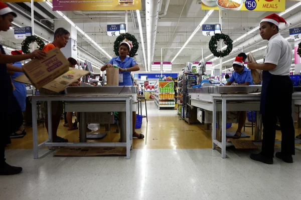 Los empleados de una tienda de comestibles sirven a los clientes en el cajero o en el mostrador . — Foto de Stock