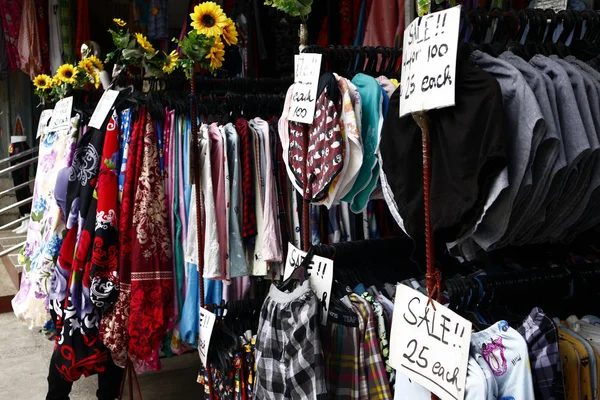 Abiti a prezzi accessibili assortiti e calzature in mostra in una bancarella di bazar — Foto Stock