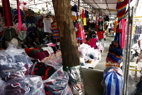 Roupas acessíveis sortidas e calçado em exposição em uma barraca de bazar — Fotografia de Stock