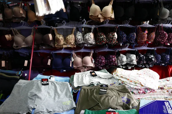 Abiti a prezzi accessibili assortiti e calzature in mostra in una bancarella di bazar — Foto Stock