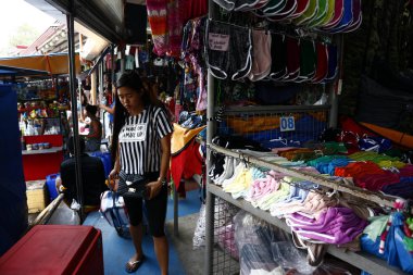 Pazarda satılan çeşitli ucuz giysi ve ayakkabılar.