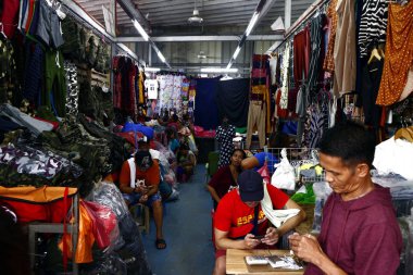 Pazarda satılan çeşitli ucuz giysi ve ayakkabılar.