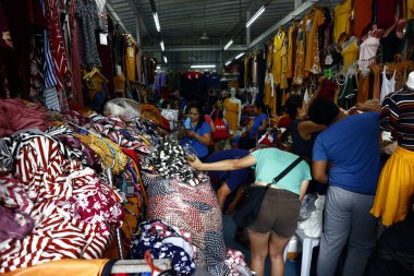 Pazarda satılan çeşitli ucuz giysi ve ayakkabılar.