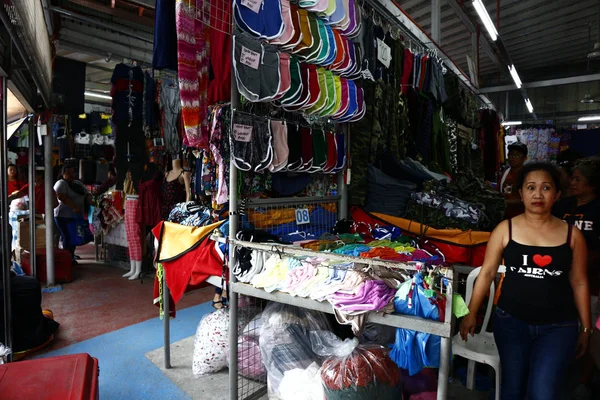 Roupas acessíveis sortidas e calçado em exposição em uma barraca de bazar — Fotografia de Stock