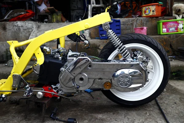 Stripped down modified motorcycle at a garage. — Stock Photo, Image