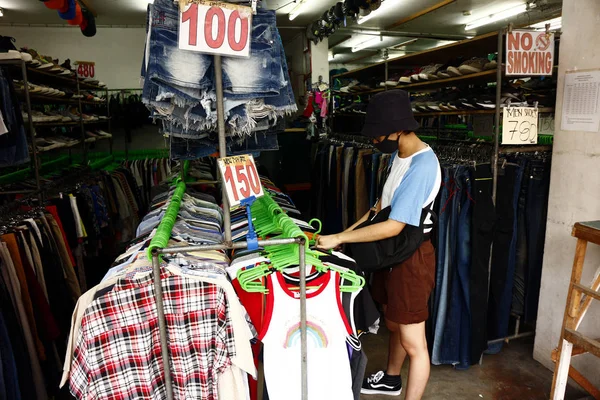 Il cliente sceglie tra una vasta gamma di vestiti in un negozio — Foto Stock