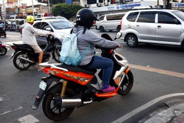 Motosiklet sürücüsü yoğun bir kavşakta trafik ışığının yeşile dönmesini bekliyor..