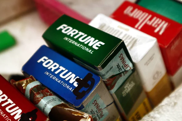 Cigarettes assorties vendues au détail ou par le bâton sur un magasin de fortune le long d'un trottoir . — Photo