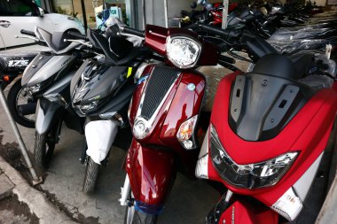 Bir motosiklet mağazasında çeşitli motosiklet ve scooterlar sergileniyor..