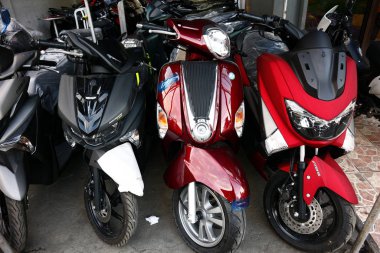 Bir motosiklet mağazasında çeşitli motosiklet ve scooterlar sergileniyor..