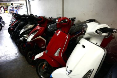 Bir motosiklet mağazasında çeşitli motosiklet ve scooterlar sergileniyor..