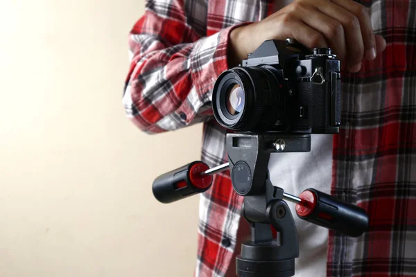 Felnőtt férfi kezében egy régi és vintage kis formátumú vagy 135mm-es film kamera egy állvány — Stock Fotó