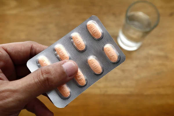 Envase de marca popular de medicamento paracetamol en la mano de una persona . —  Fotos de Stock