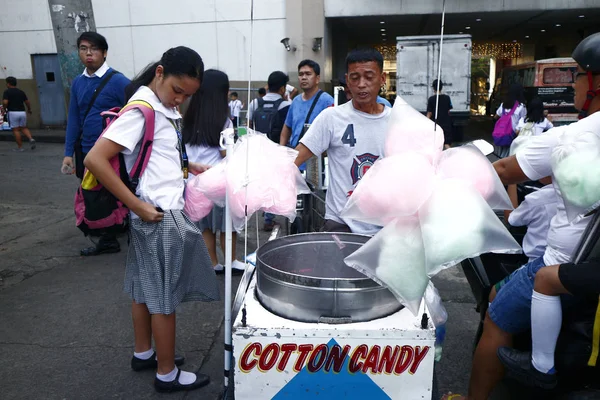 Customer buys colorful cotton candy from a street food vendor. — Stock Photo, Image