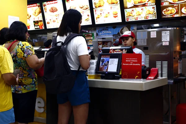 Los clientes hacen cola en el cajero de un restaurante de comida rápida y hacen su pedido . — Foto de Stock
