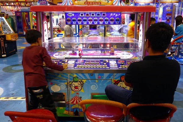 Клиенты играют в видеоигры и другие аттракционы в игровых автоматах внутри торгового центра . — стоковое фото