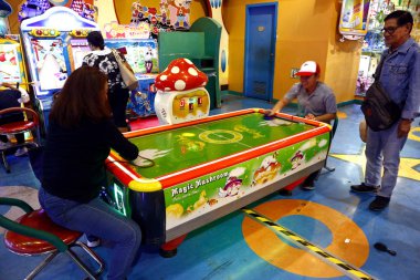 Müşteriler bir alışveriş merkezinde oyun salonu içinde video oyunları ve diğer aktiviteler oynarlar..