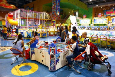 Müşteriler bir alışveriş merkezinde oyun salonu içinde video oyunları ve diğer aktiviteler oynarlar..