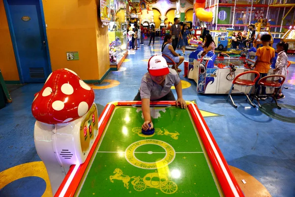 Les clients jouent à des jeux vidéo et d'autres attractions à l'intérieur d'une arcade de jeu dans un centre commercial . — Photo