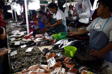 Halka açık bir markette satıcılar müşterilere balık ve diğer deniz ürünleri satar..