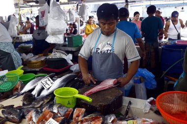 Halka açık bir markette satıcılar müşterilere balık ve diğer deniz ürünleri satar..
