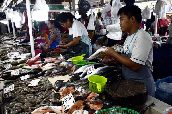 Vendedores em um mercado público molhado vendem peixe e outros frutos do mar aos clientes . — Fotografia de Stock