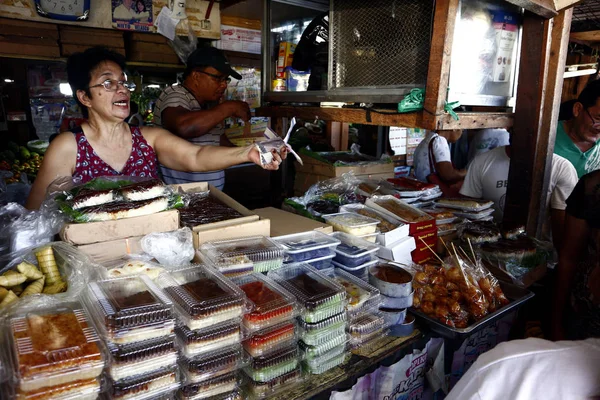 Los vendedores en un mercado público húmedo venden diversos artículos de aperitivo a los clientes . — Foto de Stock