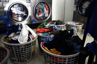 Kirli çamaşırlarla dolu çamaşır sepetleri bir çamaşırhanenin içine dizilmiştir.