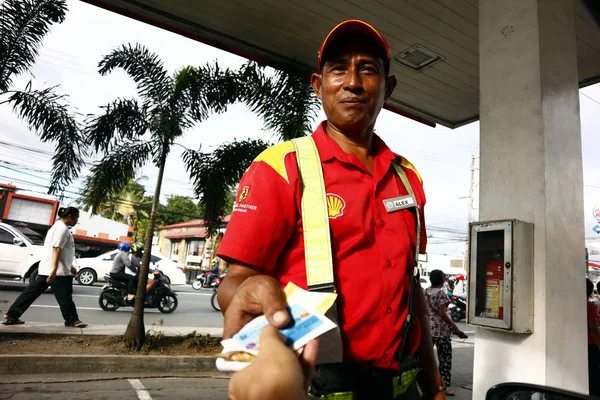 Il lavoratore di una stazione di rifornimento di gas dà a un cliente il suo resto e la sua carta fedeltà dopo il rifornimento — Foto Stock