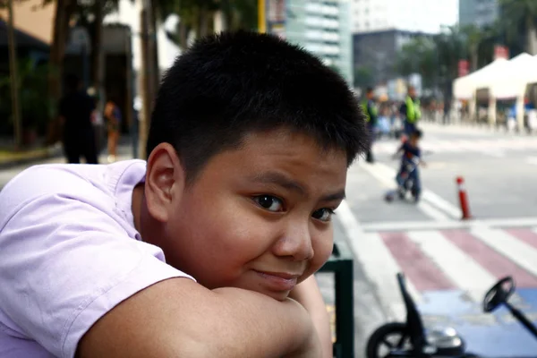 Молодой филиппинский мальчик позирует перед камерой в деловом районе — стоковое фото