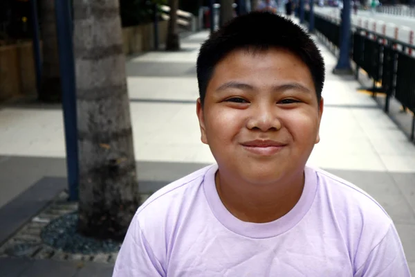 Młody filipiński chłopiec pozować do kamery podczas gdy w dzielnicy biznesowej — Zdjęcie stockowe