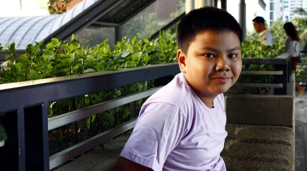 Mladý filipínský chlapec pózovat pro kameru, zatímco v obchodní čtvrti — Stock fotografie
