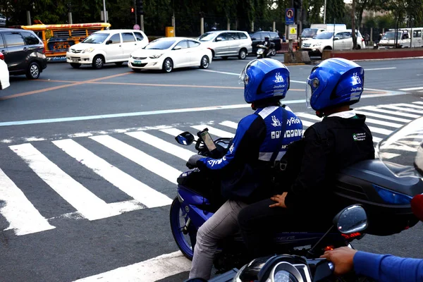 Motorista de táxi de motocicleta e seu passageiro esperam em um cruzamento para o semáforo ficar verde . — Fotografia de Stock