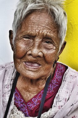 Buruşuk derili yaşlı bir Filipinli kadının portresi.