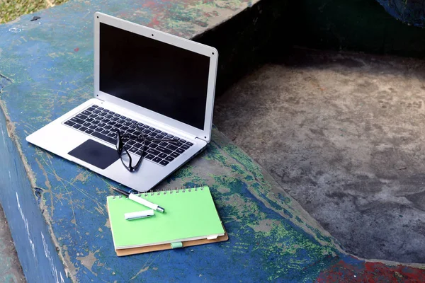 Ноутбук, очки, ноутбук и ручка в открытом парке — стоковое фото