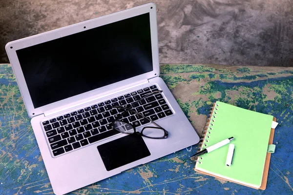 Computador de topo, óculos, caderno e caneta em um parque ao ar livre — Fotografia de Stock
