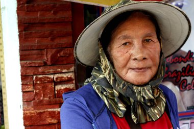 Filipinli yetişkin bir kadın sıcak ve güneşli bir günde güneş koruyucu giysisi giyer.