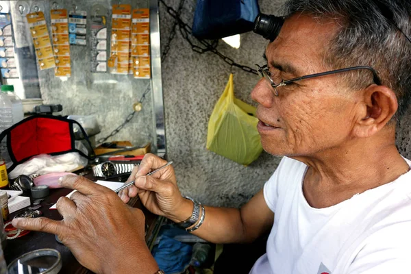 Часовой ремонтник в его импровизированной мастерской чинит старые наручные часы для клиента — стоковое фото