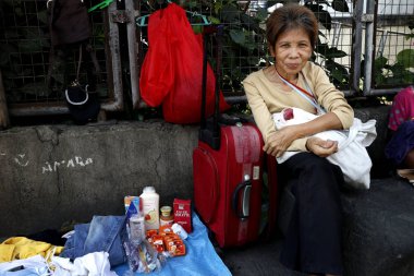Bir sokak satıcısı kaldırımda her türlü eski ve kullanılmış ayakkabı ve giysi satar.