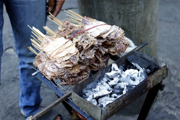 Daing na Pusit or dried squid on barbecue sticks grilled over charcoal — Stok fotoğraf