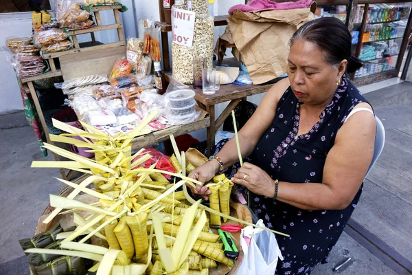 Sidewalk vendor sells Suman or steamed glutenous rice in palm tree leaves and other Filipino delicacies in her makeshift stall — Stok fotoğraf