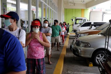 Anti-Polo Şehri, Filipinler - 18 Mart 2020: Müşteriler, hükümetin Covid-19 virüs salgını arasında sosyal mesafe koyma çağrısı doğrultusunda bir marketin önünde birbirleriyle büyük mesafeler arasında sıraya girdiler.