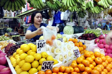 Antipolo Şehri, Filipinler - 20 Mart 2020: Stall sahibi bir kamu pazarında müşterilere taze meyve ve sebze sattı.
