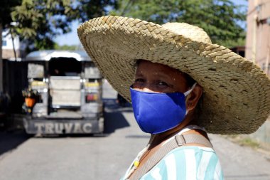 Antipolo Şehri, Filipinler - 28 Mart 2020: Yetişkin Filipinli kadın Covid 19 virüs salgınından korunmak ve sıcak güneşten korunmak için yüz maskesi takıyor.