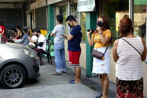Antipolo Şehri, Filipinler - 26 Mart 2020: Müşteriler Corona ya da Covid 19 virüs salgını sırasında sosyal uzaklık için bir marketin önünde kuyruk oluşturdular.