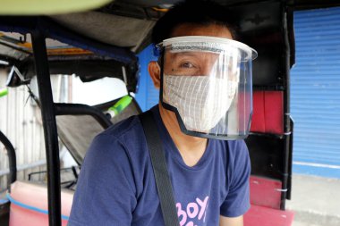 Antipolo Şehri, Filipinler - 15 Nisan 2020: Covid 19 virüsü salgını nedeniyle insanlar dışarı çıkarken yerel hükümet tarafından koruyucu yüz maskesi takmaya teşvik ediliyor.